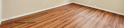 A room with a ceiling fan and wooden flooring.