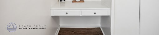 A white bathroom vanity with a mirror and a small shelf.