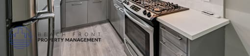 A modern kitchen with a stove top oven and a refrigerator.