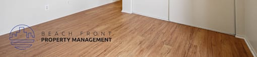 A room with a sliding door and a logo for Beach Front Property Management.