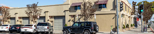 Cars are parked on the street in front of a building with a sign that says "Beach Front Property Management.".
