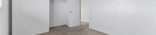 A carpeted room with a sliding door and a wall-mounted air conditioning unit.