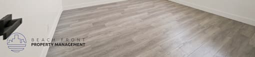 A spacious room with a ceiling fan and wooden flooring.