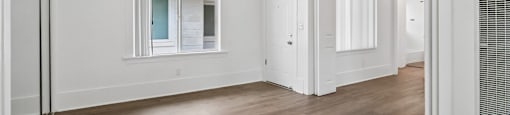 A room with a ceiling fan and wooden flooring.