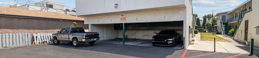 a white building with two cars parked in front of it