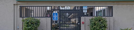 A gated entrance to a building with a sign that says "Property Management".