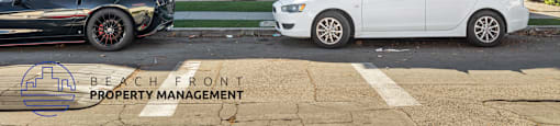 Two cars parked in front of a building with the logo Beach Front Property Management.