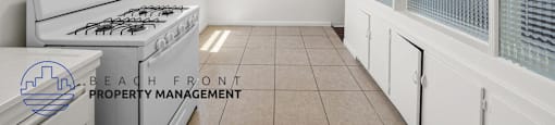 A kitchen with a stove and a logo for Beach Front Property Management.