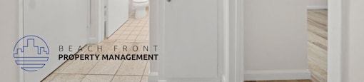 A hallway with white doors and a logo for Beach Front Property Management.