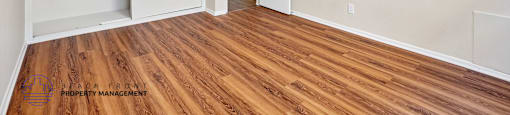 A room with a ceiling fan and wooden flooring.