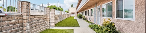 A long concrete walkway leads between two rows of houses.