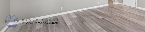 A room with a wooden floor and a wall-mounted air conditioner unit.
