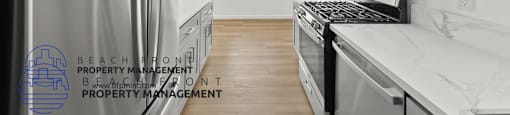 a white kitchen with stainless steel appliances and white counter tops