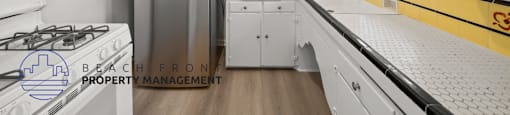 A kitchen with white cabinets and a yellow stripe on the counter.