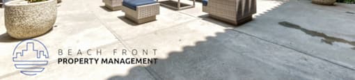A laundry room with washers and dryers and a sign that says Beach Ront Property Management.