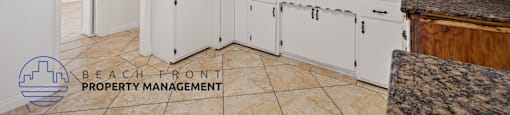A kitchen with white cabinets and a granite countertop.