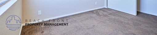 A room with a carpeted floor and a sliding door.
