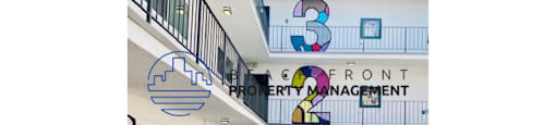 the front entrance of a building with a patio and surfboards