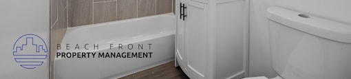 A bathroom with a tub, sink, and mirror.