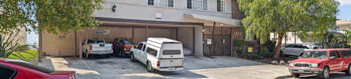 A red car is parked in front of a building with the sign "Beach Front Property Management".