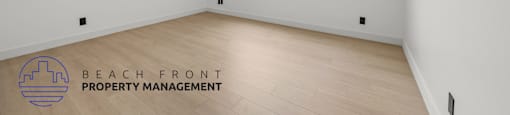 A room with a logo of Beach Front Property Management on the floor.