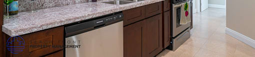 A kitchen with brown cabinets and a granite countertop.