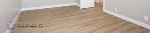 A room with a white ceiling fan and wooden flooring.