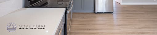 A kitchen with white cabinets and a stainless steel refrigerator.