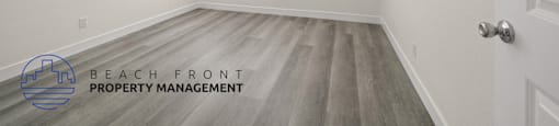 A room with a door, window, and a logo for Beach Front Property Management.