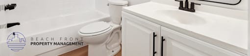 A white bathroom with a sink, toilet and bathtub.