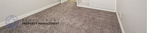 A room with a ceiling fan and carpeted floor.
