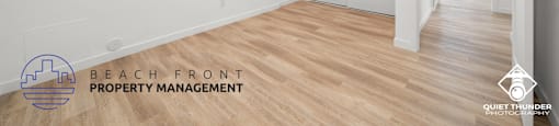 a renovated living room and hallway with white walls and wood flooring