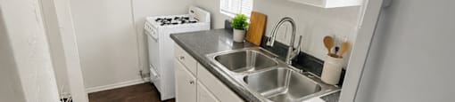 A kitchen with white appliances and wooden floors.