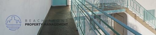 A balcony with a glass railing and a blue door.
