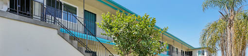 A building with a sign that reads "1475 PINE ST" is surrounded by greenery.