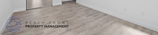 A spacious room with a logo for Beach Front Property Management.