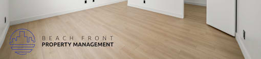 A room with a logo of Beach Front Property Management on the floor.