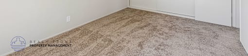 A room with a carpeted floor and a white ceiling with a light fixture.