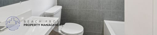 A bathroom with a toilet, sink, and a window.