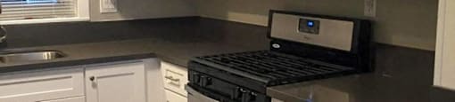 a kitchen with white cabinets and a stove and a microwave
