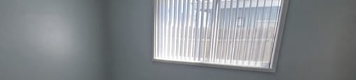 an empty living room with wood floors and a window
