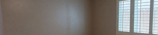 an empty living room with a ceiling fan and wood floors