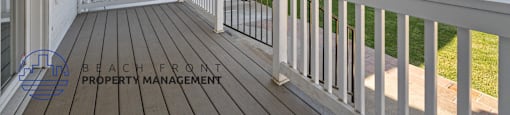 A white deck with a railing and a logo for Beachfront Property Management.