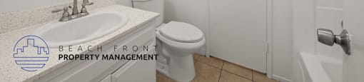 A white bathroom with a sink, toilet, and bathtub.