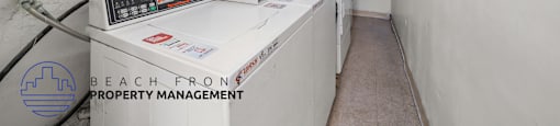 A white industrial room with a control panel and a sign that says Beach Front Property Management.