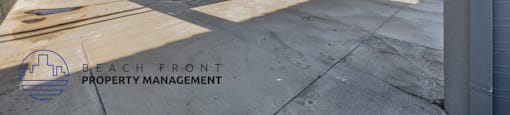 A parking garage with a logo for Beach Front Property Management.