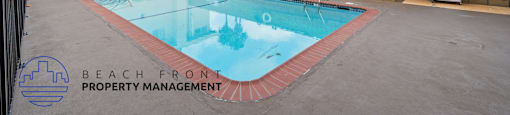 A pool with a red border and a building in the background.