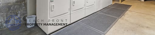 A large industrial room with a row of white cabinets and a sign that says "Each Front Property Management".