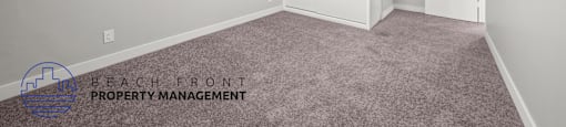 A room with a ceiling fan and carpeted floor.