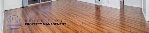 A spacious room with wooden floors and white walls, with a view of a balcony outside.